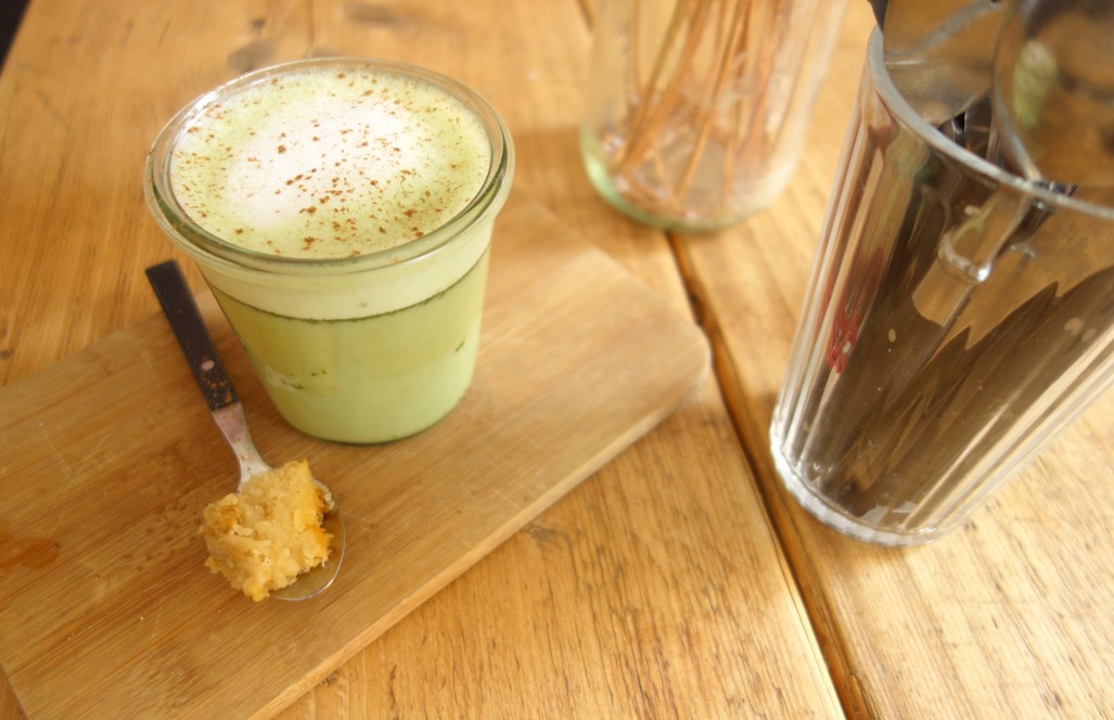 Matcha-Latte mit Kokosmilch und Kuchenstück im Möhren-Milieu