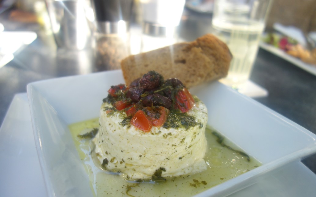 Gegrillter Kuhmilchfeta aus der Duftfolie mit Kirschtomaten, Oliven, Basilikum-Pesto und Brot. Das Cubo Negro kann auch "ohne Fleisch".