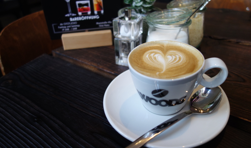 Der Cappuccino im Woods schmeckt gut, die Kunstpflanze auf dem Tisch stört leider etwas.